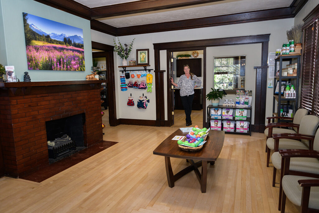 Photo of Dr. Anja Hunter in doorway of holistic veterinary clinic showcasing lobby and natural pet supplements.